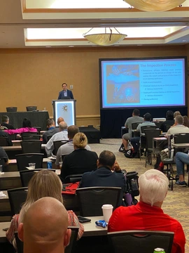 Trent Cotney speaking to a crowd of people at an event.